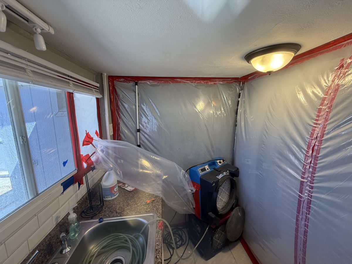 Pueblo project photo 5: Plastic containment sealing off the kitchen, with air filtration running.